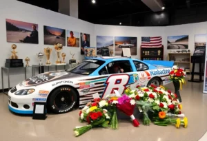 Memorial display showing race car and trophies dedicated to Greg Biffle