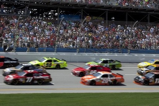 NASCAR stock cars racing past a full grandstand